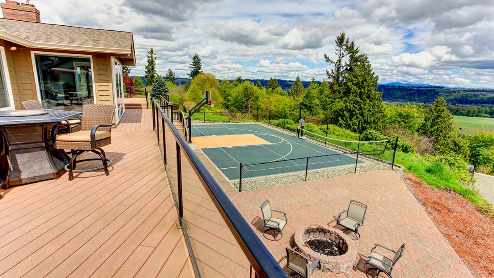 An outdoor pavilion with a dining table, chairs, and a wall-mounted smart TV displaying entertainment options.